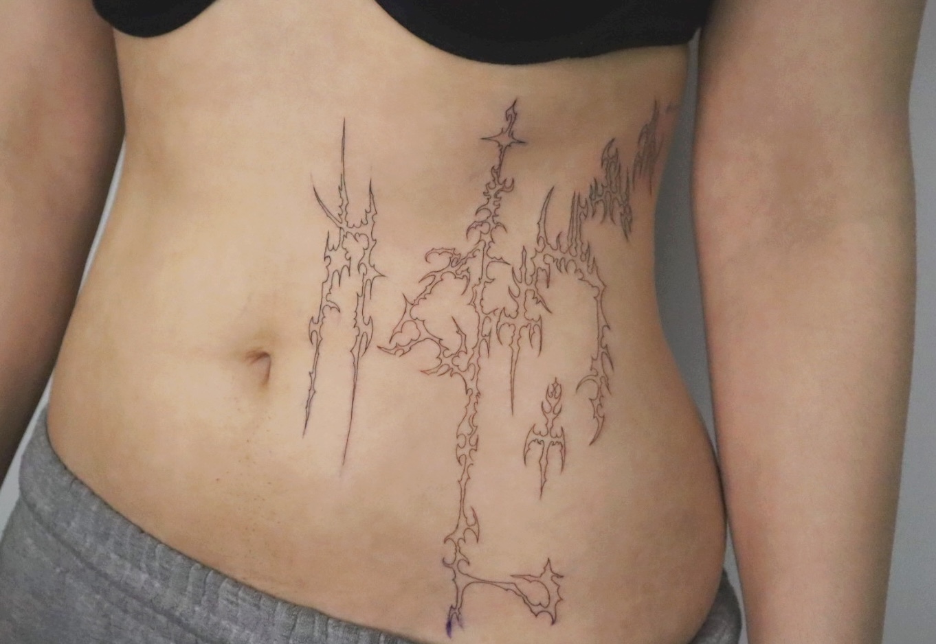 Abstract tattoo design on a person's abdomen