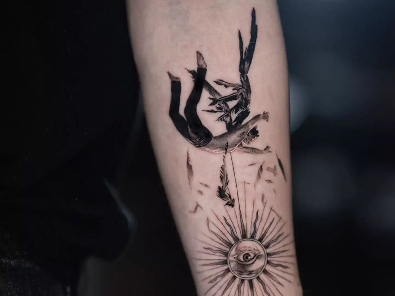 Intricate tattoo featuring a diver and sun design on an arm