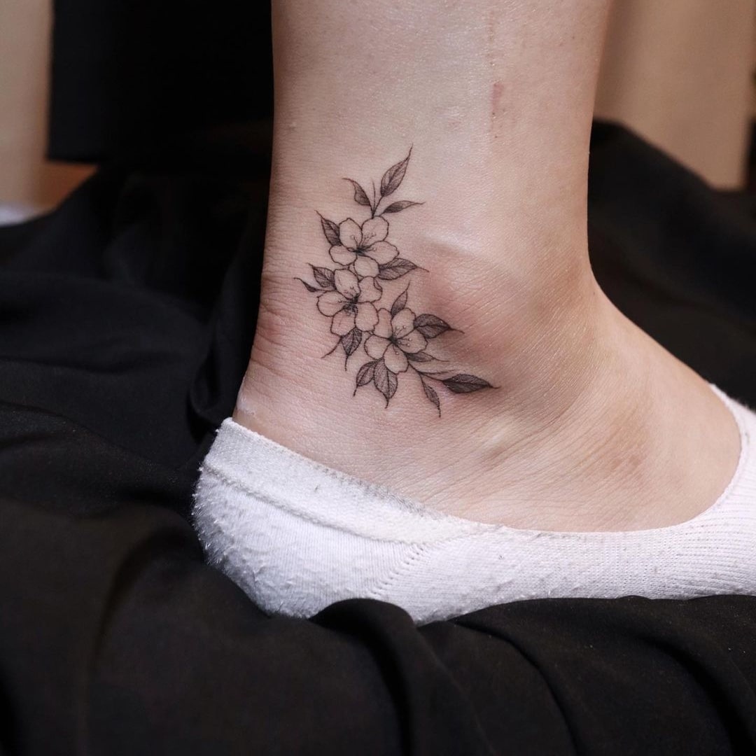 Delicate floral ankle tattoo design