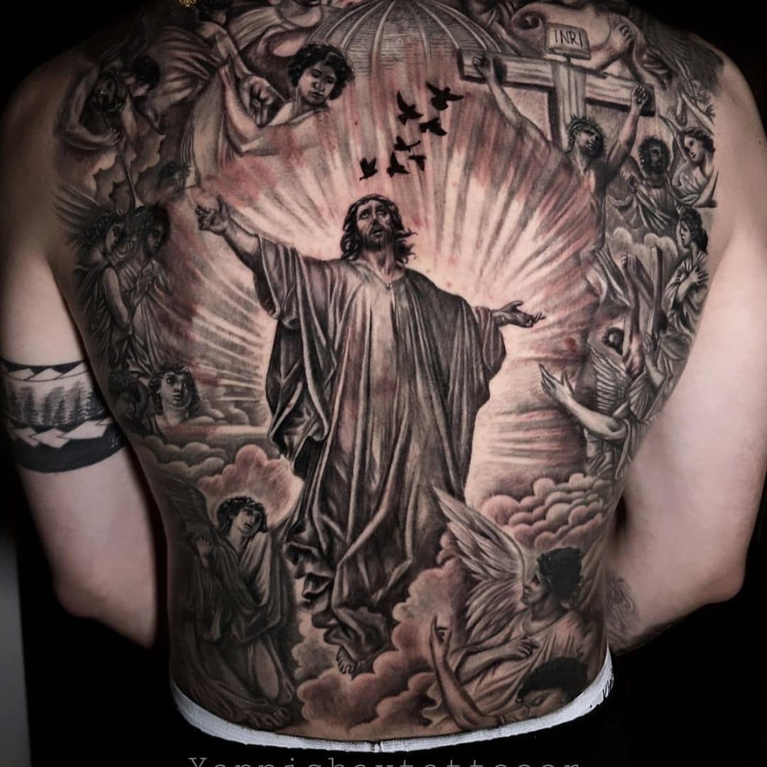 Detailed tattoo artwork depicting religious scenes and angels on a man's back.