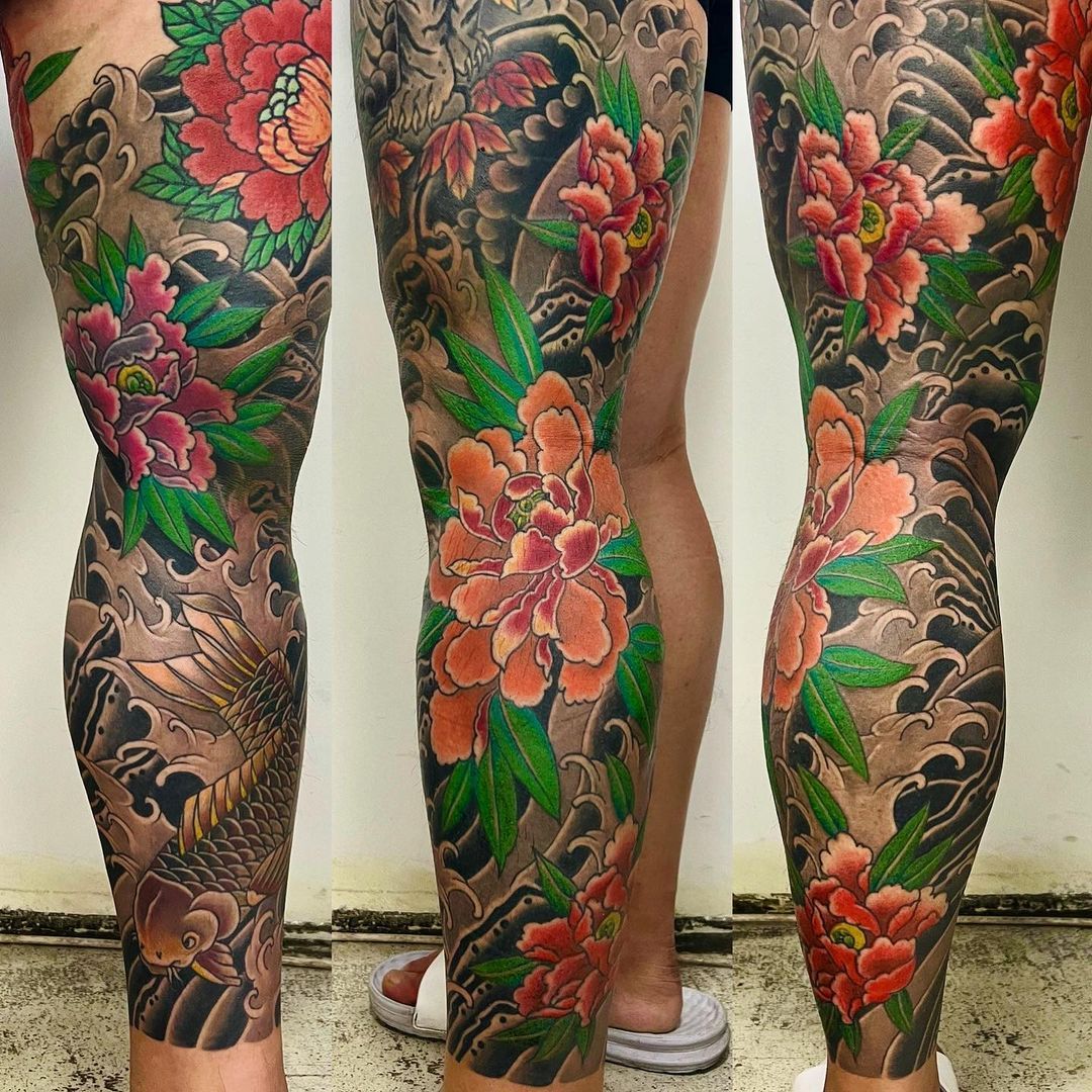Vibrant floral and koi fish tattoo on leg