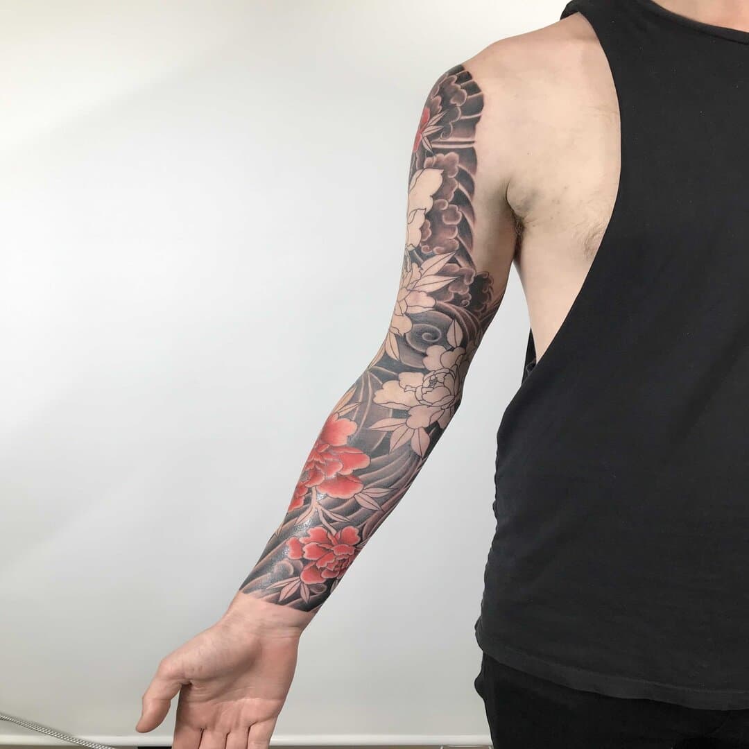 Colorful floral tattoo sleeve on a person's arm.