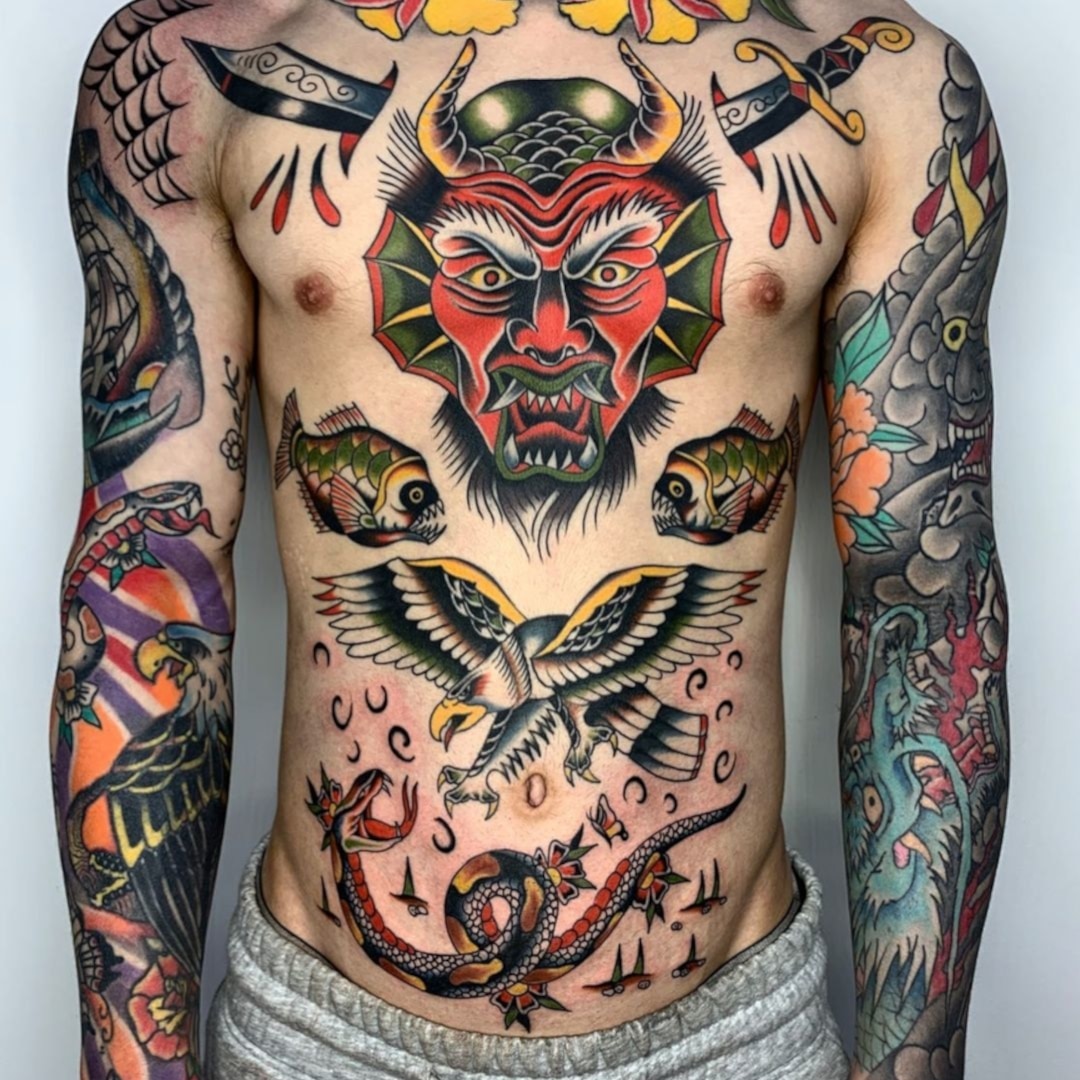 Tattoo art featuring devil face, fish, eagle, and snake