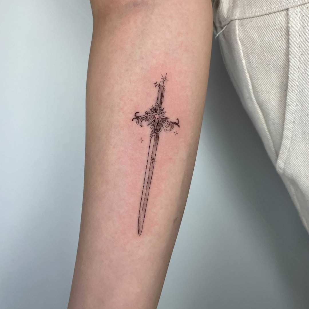 Delicate sword tattoo on a person's arm