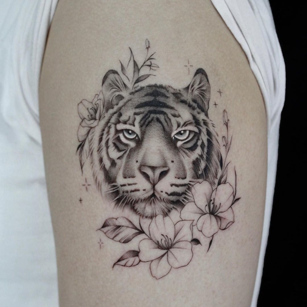 Detailed tattoo of a tiger's face surrounded by flowers