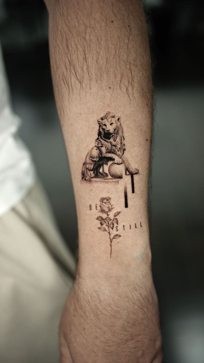 Tattoo of a lion and a rose with the phrase 'be still'