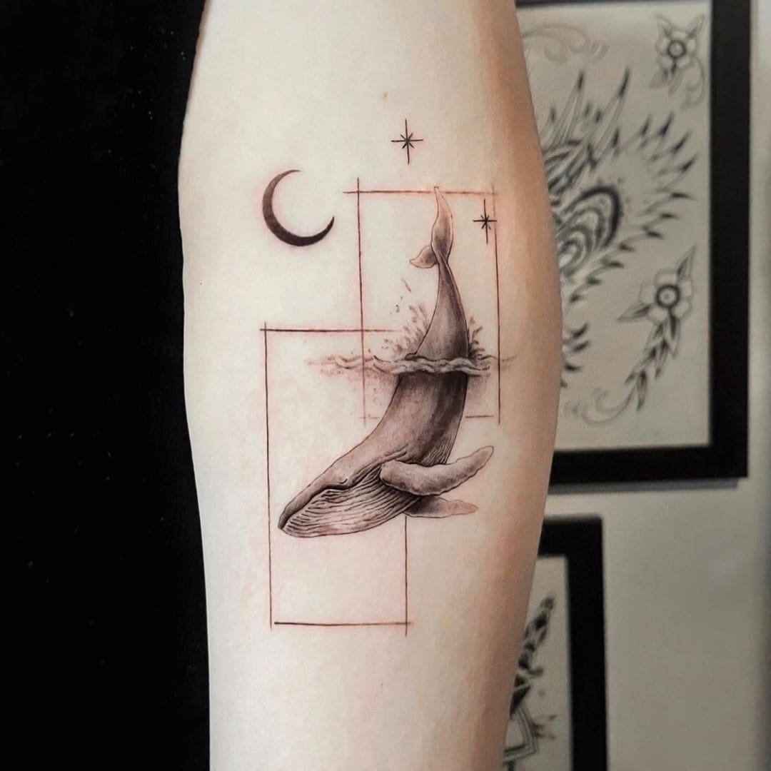Tattoo of a whale with geometric elements on an arm.