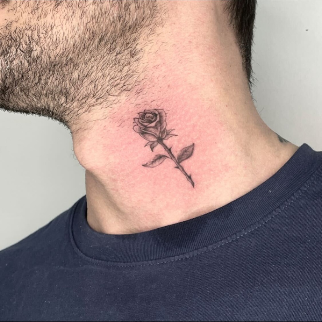 Black and white rose tattoo on neck