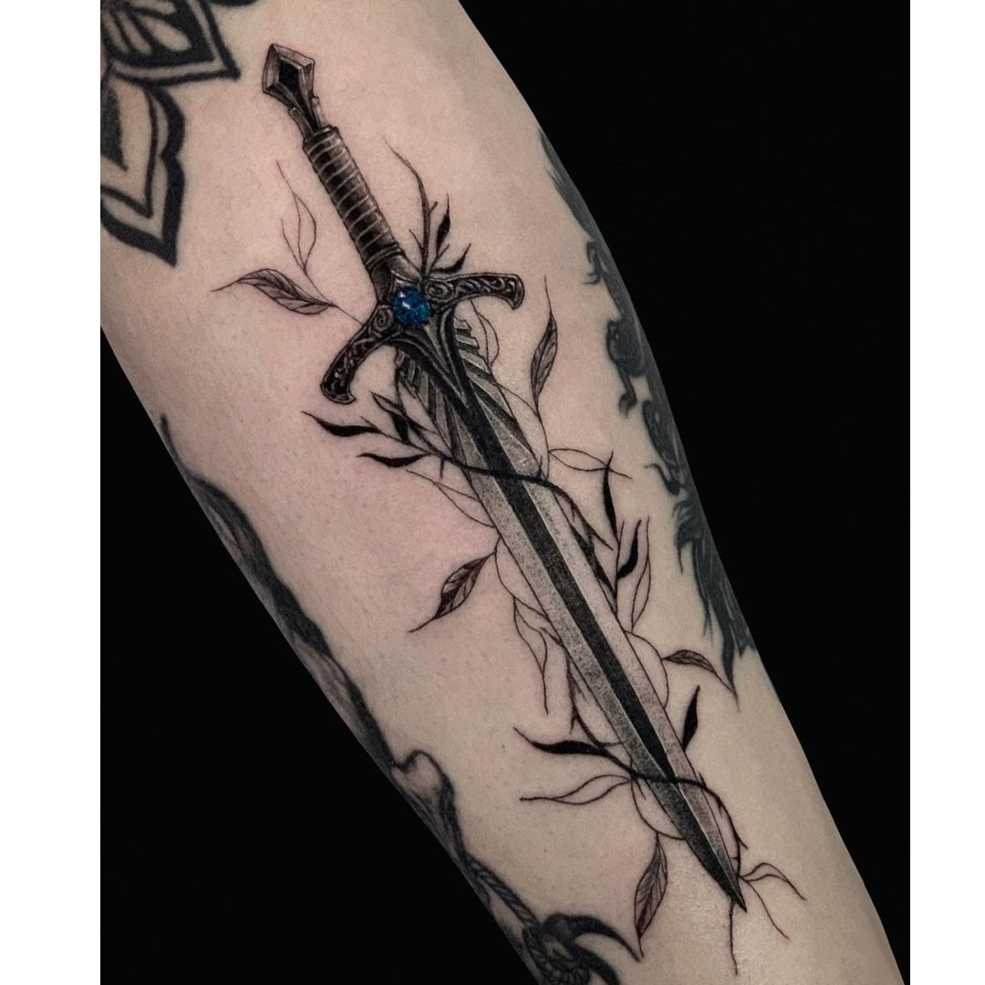 Realistic sword tattoo design with vines on arm