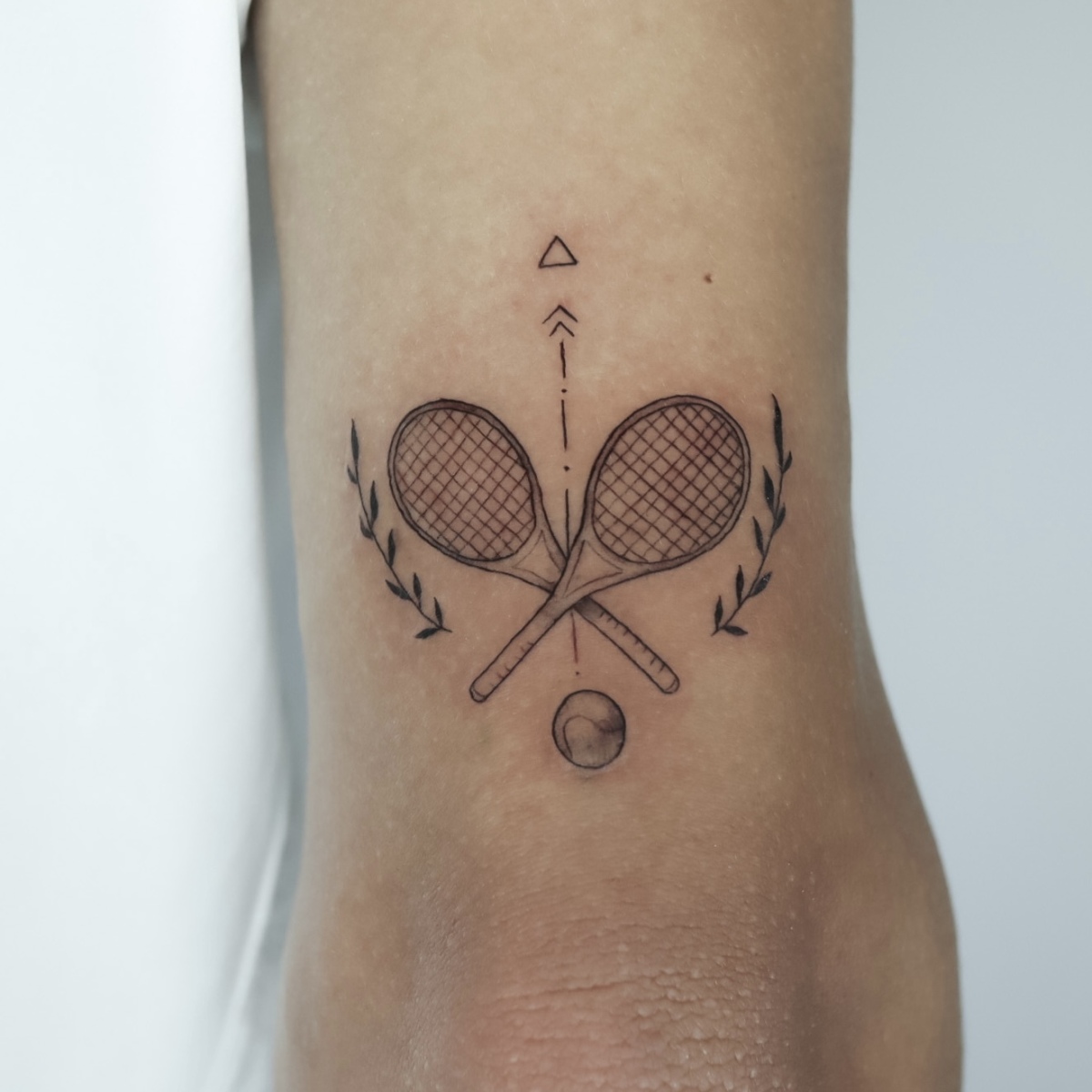 Tennis tattoo design featuring racquets and a ball