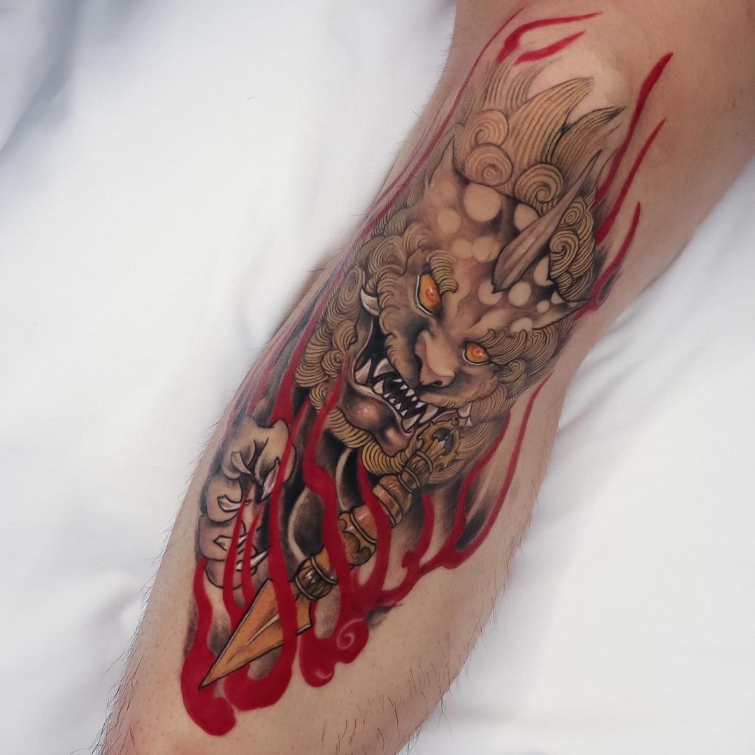 Detailed tattoo of a mythical creature with red accents