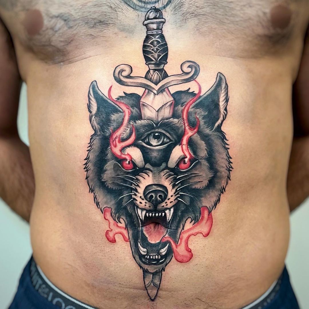 Intricate wolf tattoo with sword and flames on torso