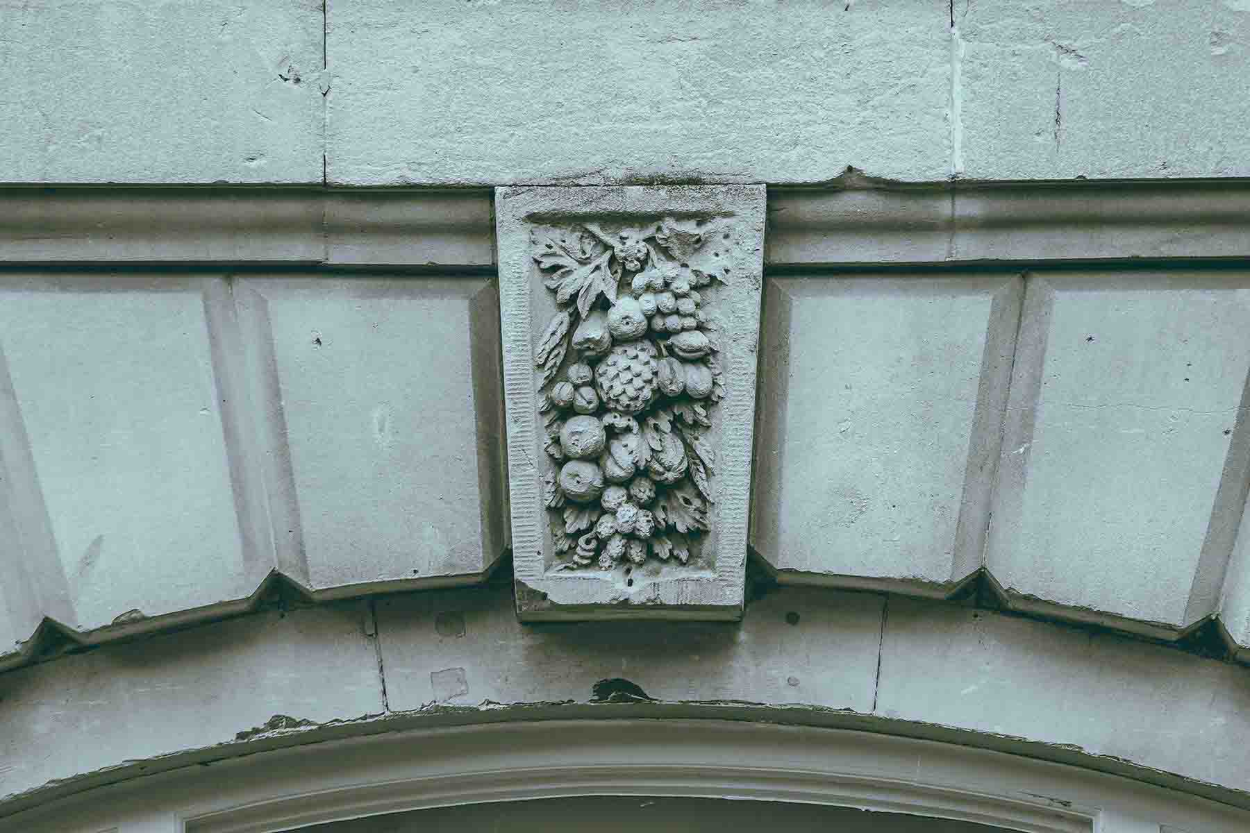 Ornate stone carving of fruits on a building facade